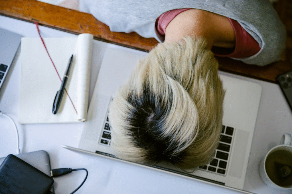 Exhausted man with head down on keyboard, struggling with fatigue